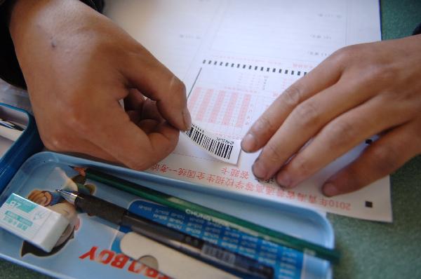 A student pastes a barcode on answer sheet before the college entrance exam, or Gaokao, in Gyegu Town of the quake-hit Tibetan Autonomous Prefecture of Yushu, northwest China's Qinghai Province, June 7, 2010. 