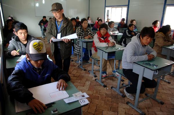 A staff member distributes answer sheets before the college entrance exam, or Gaokao, in Gyegu Town of the quake-hit Tibetan Autonomous Prefecture of Yushu, northwest China's Qinghai Province, June 7, 2010. 