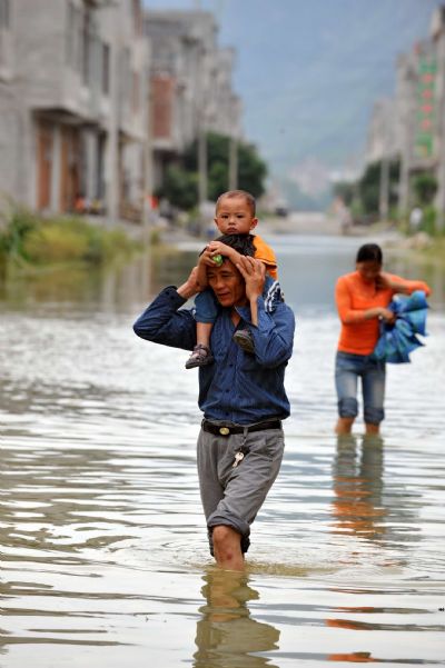 Residents walk on a flooded road in Chengjiang Town of Yao Autonomous County of Du&apos;an, southwest China&apos;s Guangxi Zhuang Autonomous Region, June 7, 2010. 