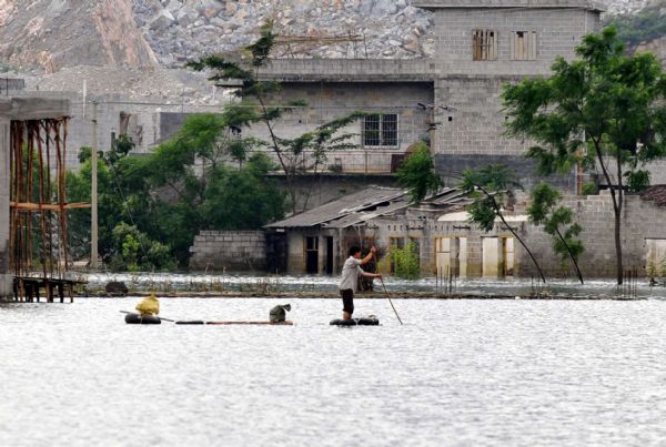 A resident rows a raft in Chengjiang Town of Yao Autonomous County of Du&apos;an, southwest China&apos;s Guangxi Zhuang Autonomous Region, June 7, 2010. 