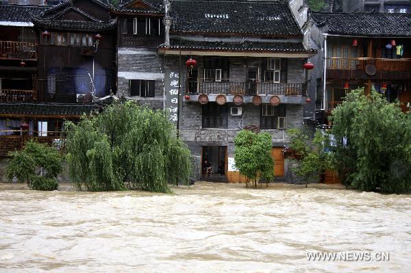 Torrential water flow of the Tuojiang River surges up and inundates part of the street, at Fenghuang County, central China&apos;s Hunan Province, June 8, 2010.
