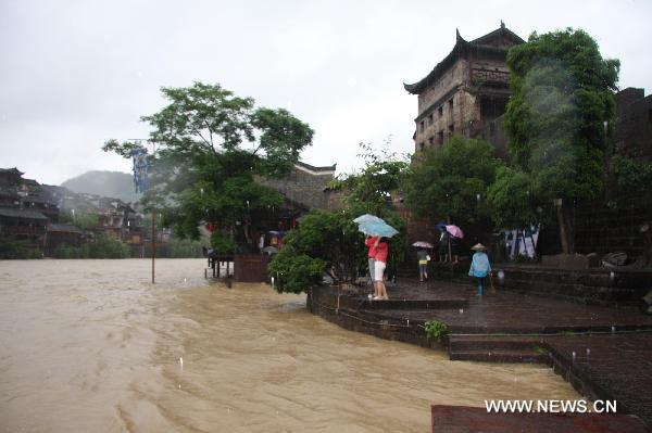 Torrential water flow of the Tuojiang River surges up and inundates part of the street, at Fenghuang County, central China's Hunan Province, June 8, 2010.