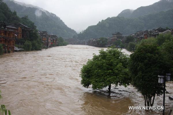 Torrential water flow of the Tuojiang River surges up and inundates part of the streets, at Fenghuang County, central China&apos;s Hunan Province, June 8, 2010. 