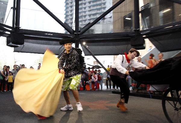 A tourist plays the role of a bullfighter while taking part in a performance at the Madrid Case Pavilion of Urban Best Practices Area (UBPA) at the World Expo Park in Shanghai, east China, on June 10, 2010.