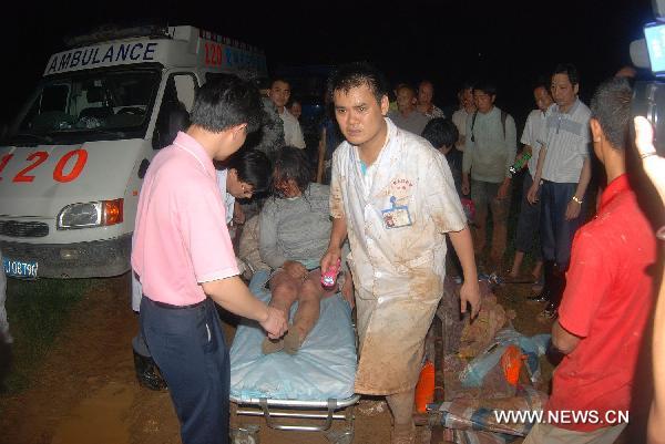A wounded personnel is transfered out of the Huangshachong tree farm to receive medical treatment in Hezhou, southwest China's Guangxi Zhuang Autonomous Region, June 16, 2010. 