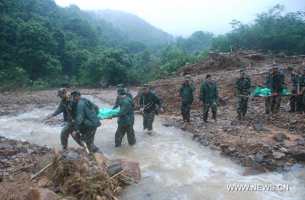 Soldiers carry the bodies of victims out of the Huangshachong tree farm in Hezhou, southwest China's Guangxi Zhuang Autonomous Region, June 16, 2010. The mountain torrent, which occurred in the Huangshachong tree farm Monday night, has left 5 people dead, 5 injured and 3 others missing.