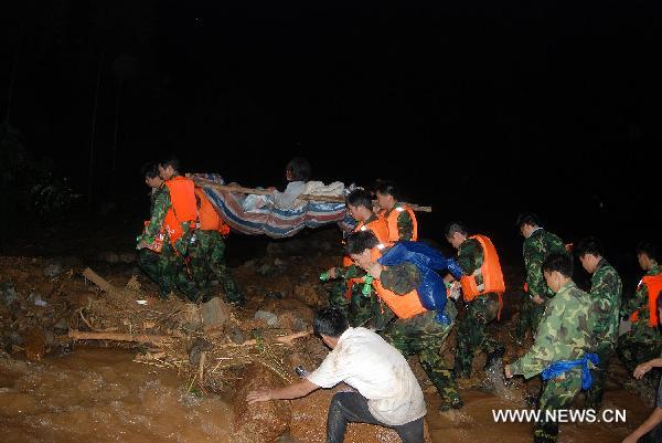 Soldiers and local militiaman emergency team members transfer a wounded personnel out of the Huangshachong tree farm in Hezhou, southwest China's Guangxi Zhuang Autonomous Region, June 16, 2010. 