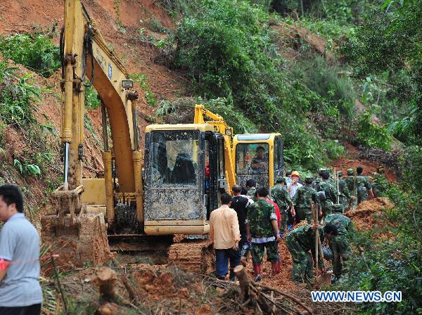 Rescuers repair a road in Shuangshang village of Cangwu, county of southwest China's Guangxi Zhuang Autonomous Region, June 16, 2010.