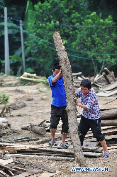 Villagers remove wood in Shuangshang village of Cangwu, county of southwest China's Guangxi Zhuang Autonomous Region, June 16, 2010. 