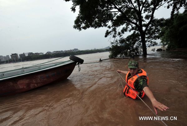 A rescuer works on a flooded street in Guilin, southwest China's Guangxi Zhuang Autonomous Region, June 17, 2010. Heavy rainfalls caused flood in Guilin on Thursday. 