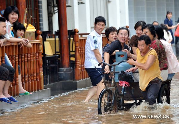 Women citizens sit in a tricycle on a flooded street in Guilin, southwest China's Guangxi Zhuang Autonomous Region, June 17, 2010. 