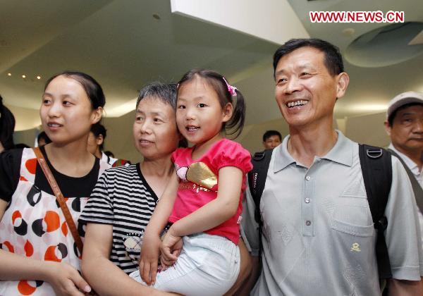 Four-year-old Jiang Yuxiao (R) from Taicang of east China&apos;s Jiangsu Province visits the Germany Pavilion with her parents and grandmother at the World Expo Park in Shanghai, east China, June 20, 2010. 