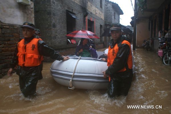 A squad of armed policemen takes the hovercraft in search of the deluge-beleaguered people to transfer them towards the safety belt in a preemptive rescue operation against heavy rainfall, at Jintan Town, Ji'an City, east China's Jiangxi Province, June 20, 2010.