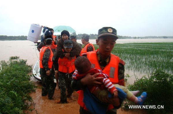 A squad of armed policemen takes the hovercraft in search of the deluge-beleaguered people to transfer them towards the safety belt in a preemptive rescue operation against heavy rainfall, at Jintan Town, Ji'an City, east China's Jiangxi Province, June 20, 2010.