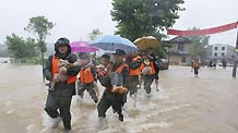 A squad of armed policemen carry the children towards the safety belt in their preemptive rescue operation against heavy rainfall, at Jintan Town, Ji'an City, east China's Jiangxi Province, June 20, 2010.