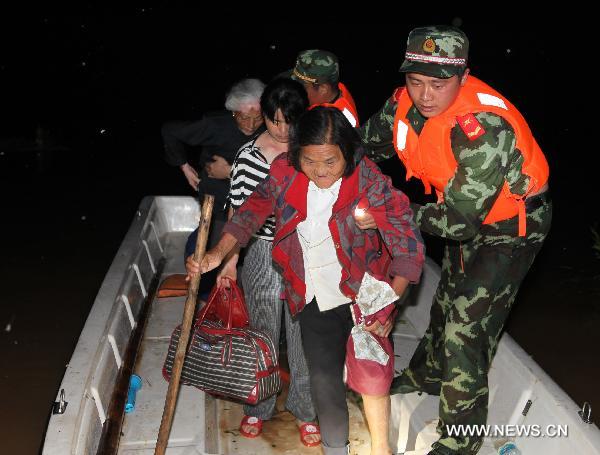 Paramilitary policemen help evacuate residents from Wanjia village of Fuzhou City, east China's Jiangxi Province, June 22, 2010.