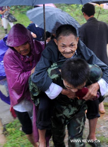 Paramilitary policemen help evacuate residents from Wanjia village of Fuzhou City, east China's Jiangxi Province, June 22, 2010.