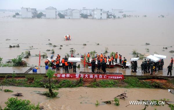 Paramilitary policemen conduct rescue operations after a dike bust in Fuzhou City, east China's Jiangxi Province, June 22, 2010.