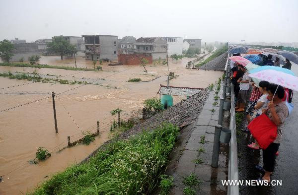 Rescued villagers look over their flood damaged villages in Luozhen town of Fuzhou City, east China's Jiangxi Province, June 22, 2010.