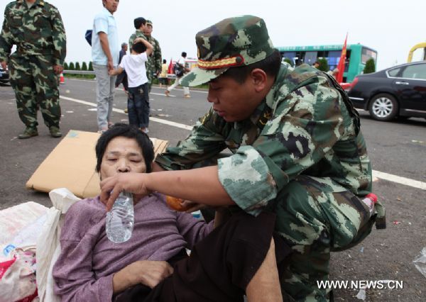 A firefighter feeds water to a refugee in Fuzhou City, east China's Jiangxi Province, on June 23, 2010. A new round of rainfall will hit Jiangxi Province from June 24 to June 26, according to local meteorological department. 