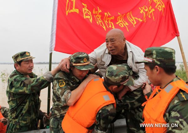 Firefighters transfer trapped residents to safe place in Fuzhou City, east China's Jiangxi Province, on June 23, 2010.