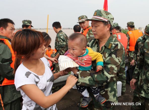 Firefighters transfer trapped residents to safe place in Fuzhou City, east China's Jiangxi Province, on June 23, 2010.