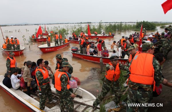 Firefighters transfer trapped residents to safe place in Fuzhou City, east China's Jiangxi Province, on June 23, 2010.