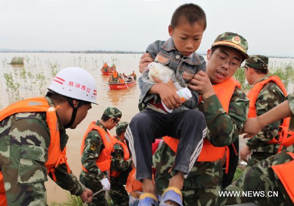 Firefighters transfer trapped residents to safe place in Fuzhou City, east China's Jiangxi Province, on June 23, 2010.