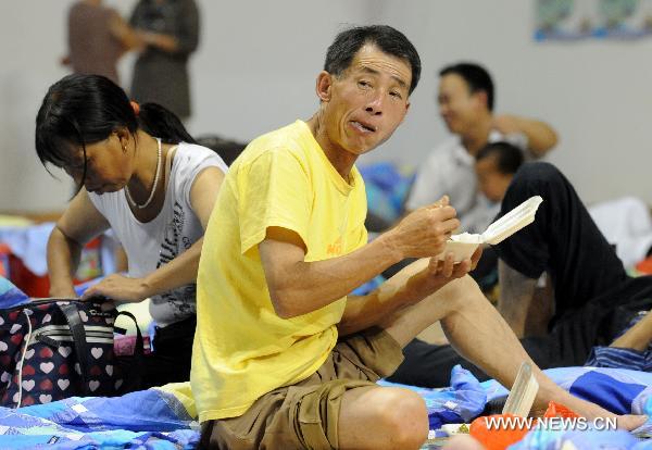 A man affected by floods has a meal in a gymnasium serving as an evacuation center in Wuzhou City of east China's Jiangxi Province, June 23, 2010. 