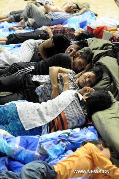 People affected by floods sleep in a gymnasium serving as an evacuation center in Wuzhou City of east China's Jiangxi Province, June 23, 2010. 