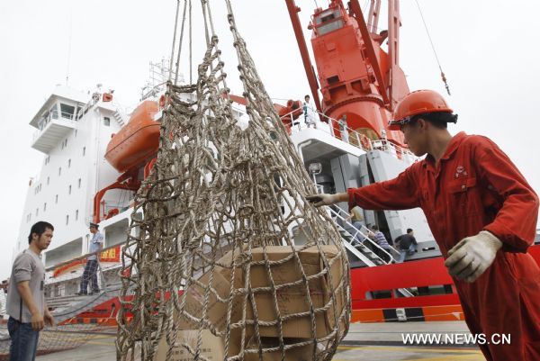 A worker conducts the arm of derrick to load goods on the icebreaker 'Snow Dragon' in the port in Shanghai, east China, June 24, 2010. 
