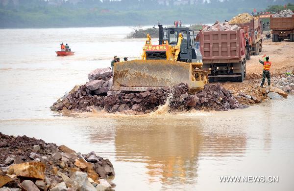 Soldiers work at the breach site of the dike at the Changkai section of the Fuhe River, in Fuzhou City, east China's Jiangxi Province, June 27, 2010. 