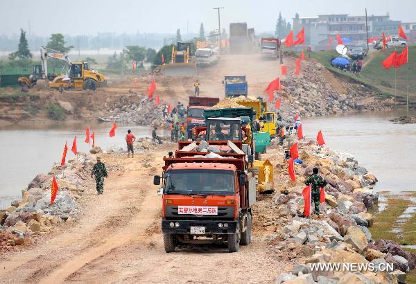 Soldiers work at the breach site of the dike at the Changkai section of the Fuhe River, in Fuzhou City, east China's Jiangxi Province, June 27, 2010. 