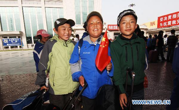 Enqiu Naobu (C, front), a student of a middle school from quake-hit Yushu Tibetan Autonomous Prefecture, prepares to board the train in Xining, capital of northwest China&apos;s Qinghai Province, June 27, 2010. 