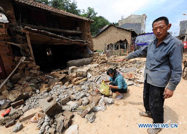 A farmer stands near his damaged house in Malong County of southwest China&apos;s Yunnan Province, June 27, 2010.