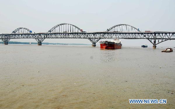 Several vessels sail on the up-surging Yangtze River at the section of Jiujiang, east China's Jiangxi Province, June 27, 2010.