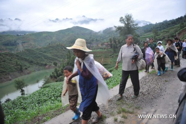 Local residents evacuate from the site of a landslide in Guanling County of southwest China's Guizhou Province, on June 28, 2010. 