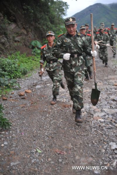 Soldiers rush to the site of a landslide in Guanling County of southwest China's Guizhou Province, on June 28, 2010. 