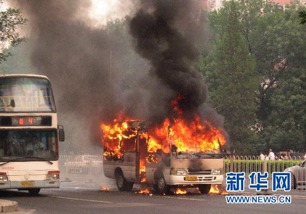 A minivan burns after it self-ignited on Xuanwumen West Street, Beijing on June 28, 2010.