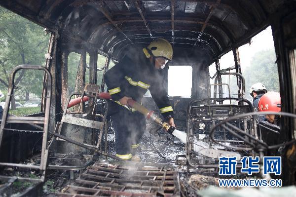 Firefighters put out a minivan fire on Xuanwumen West Street, Beijing on June 28, 2010. 