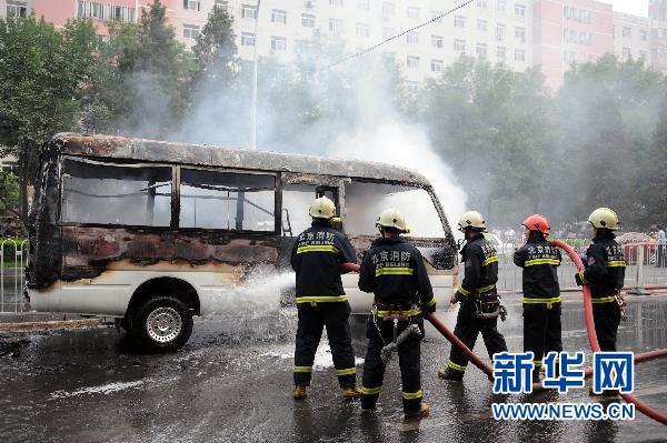 Firefighters put out a minivan fire on Xuanwumen West Street, Beijing on June 28, 2010. 