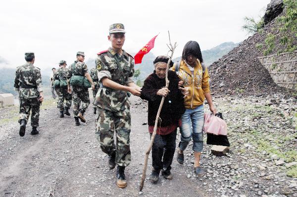 A squadron of armed policemen help local people shifting to safety belt, in Dazhai Village, Gangwu Township, of Guanling Bouyei and Miao Autonomous County, southwest China&apos;s Guizhou Province, June 28, 2010. 
