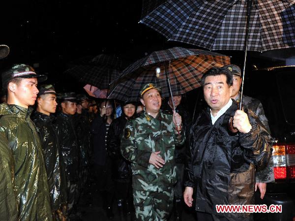 Chinese Vice Premier Hui Liangyu (1st R) talks with soldiers who participate in the rescue work in Dazhai Village, Gangwu Township of Guanling County, in southwest China's Guizhou Province, June 29, 2010. 