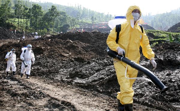 Epidemic prevention workers disinfect the site where a rain-triggered landslide occurred in Guanling County of Anshun City, southwest China's Guizhou Province, July 2, 2010. 