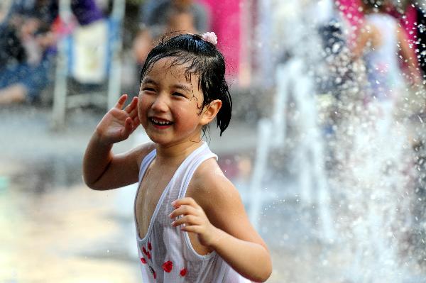 A girl plays at a fountain in Shenyang, capital of northeast China's Liaoning Province, on July 3, 2010. Hot weather swept most regions in northern, central and southern China these days, with temperature of some regions soaring to 39 degrees celsius.