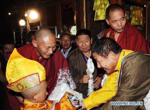 A candidate with the secular name Losang Doje (L, front) is blessed by lamas after he was selected as the reincarnation of the 5th Living Buddha Dezhub in Lhasa, capital of southwest China's Tibet Autonomous Region, on July 4, 2010. 