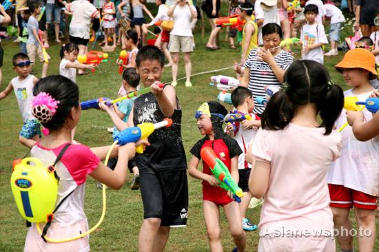 Children splash water on each other with water guns in Nanjing in East China's Jiangsu province, July 4, 2010. [China Daily/Asianewsphoto]