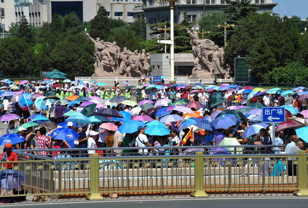 Tourists use umbrellas to block the fierce sun at Tian'anmen Square in Beijing on July 6, 2010. A heat wave has been scorching the Chinese capital for five straight days, with temperatures climbing up to 41.8 C at 1:30 PM on Tuesday.