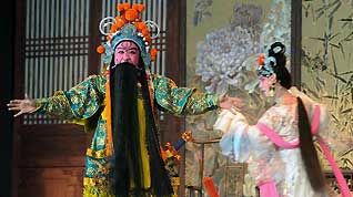 An actor (L) and an actress from the Liuziju opera theater of Shandong Province perform a traditional Chinese opera at the 2010 World Expo in Shanghai, east China, July 9, 2010, the second day of the Shandong Promotion Week.