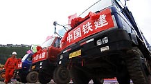 Vehicles are seen at the site where a foundation laying ceremony is held in Yushu, northwest China's Qinghai Province, July 10, 2010.